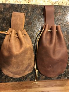 two brown leather bags sitting on top of a counter