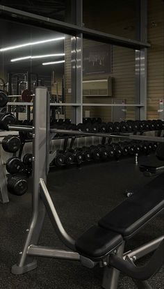 an empty gym with rows of weight benches