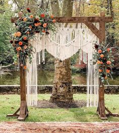 an outdoor wedding ceremony setup with macrame and flowers on the altar, surrounded by greenery