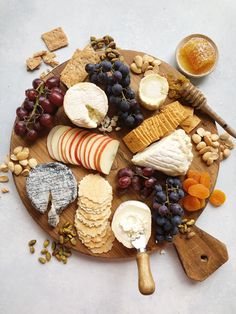 an assortment of cheeses and crackers on a wooden platter