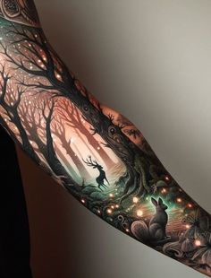 a person with a tattoo on their arm that has trees and animals in the woods