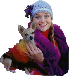 a woman is holding a small dog wearing a purple coat and a knitted hat