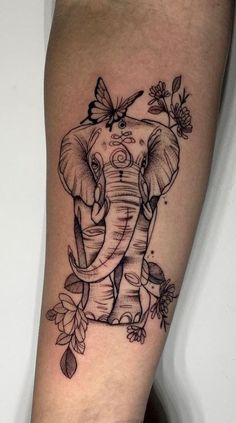 an elephant with flowers on its head is shown in this tattoo design, which features butterflies and leaves