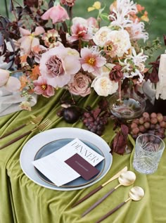 the table is set with flowers and place settings