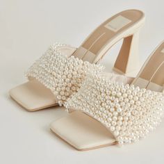 a pair of wedding shoes with pearls on them