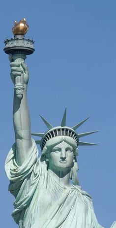 the statue of liberty has a golden crown on it's head and is holding a torch in its hand