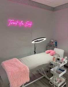 a pink neon sign above a bed in a room