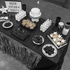 a black and white photo of desserts on a table at a rock star party