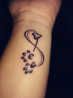 a dog paw and heart tattoo on the wrist