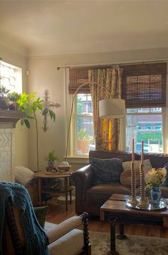 a living room filled with furniture and a fire place in front of a window on top of a hard wood floor