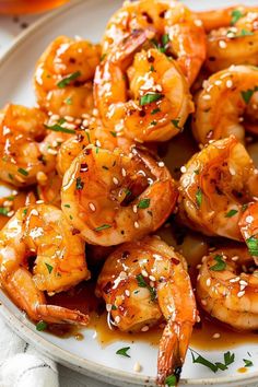 a white plate topped with shrimp covered in sesame seeds