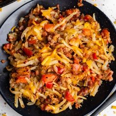 a skillet filled with ground beef, cheese and tomato sauce on top of a white table