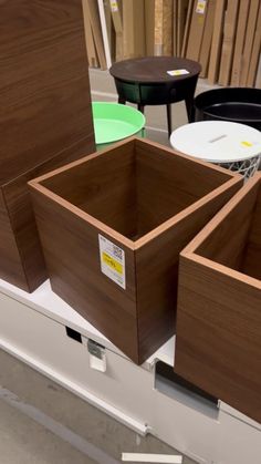 three wooden boxes sitting on top of a shelf next to other tables and stools