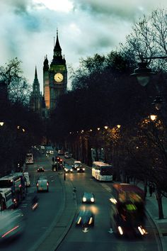 black and white photograph of big ben in the distance with cars driving down the street