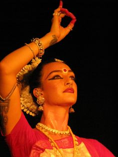 a woman with her hands up in the air while wearing jewelry and bracelets on top of her head