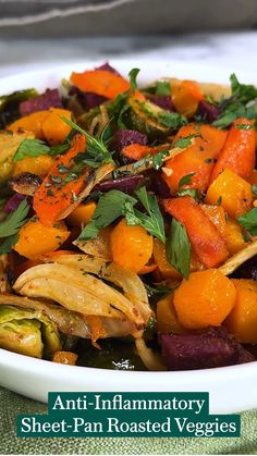 a white bowl filled with assorted veggies on top of a table