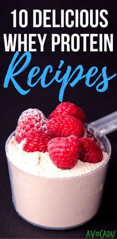 a bowl filled with raspberries on top of a black table next to a spoon