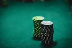 two poker chips sitting on top of a green table