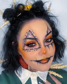 This scarecrow makeup takes a more artistic approach, featuring intricate stitching and vibrant orange hues. The standout feature is the stitched triangle above one eye, which adds a unique touch to the traditional scarecrow look. The makeup is complemented by blackened lips and exaggerated eyelashes, making it both spooky and pretty. The addition of wheat accents in the hair enhances the scarecrow Halloween makeup art theme.   Photo credit by: @michpage Makeup Ideas Unique, Cute Scarecrow Makeup, Scarecrow Makeup Ideas, Art Makeup Ideas, Pumpkin Makeup Ideas, Makeup Ideas For Halloween, Cute Clown Makeup, Cute Scarecrow