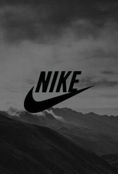 a black and white photo with the word nike on it's side in front of mountains