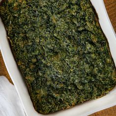 a square casserole dish filled with spinach