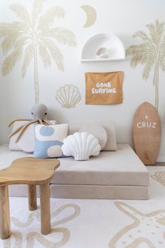 a living room filled with furniture and wallpaper covered in palm tree decals on the walls