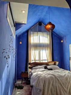 a bedroom with blue walls and a bed in the corner that has a white bedspread on it