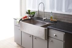 a stainless steel kitchen sink with black counter tops