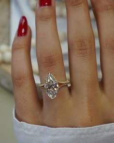 a woman's hand with a ring on it and a diamond in the middle