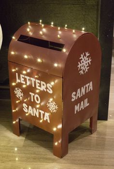 a lighted letter to santa mailbox sitting on the floor