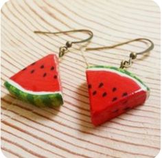 two slices of watermelon are hanging from earrings