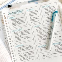 a pen sitting on top of an open notebook next to some papers with writing in it