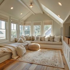 a living room filled with lots of furniture next to two windows and a large rug on the floor