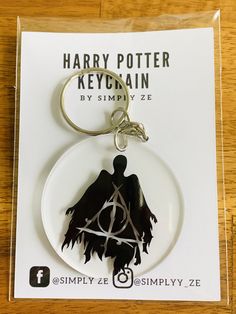 a harry potter keychain with the deathly hall symbol on it's front