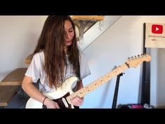 a person playing an electric guitar in a room