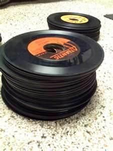 two black records sitting on top of a counter next to a pair of headphones