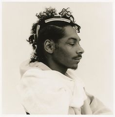 a black and white photo of a man with curly hair wearing a head band on top of his head