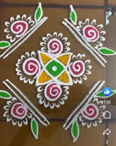 an intricate design on the floor in front of a door with green leaves and red flowers