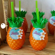 three orange pineapples with green stems and flowers on them sitting on a shelf