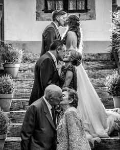 a group of people that are standing in front of each other kissing on the steps