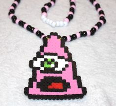 a pink and black beaded necklace on a white surface