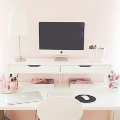 a white desk with a computer monitor and keyboard