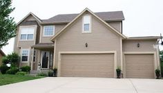 a large house with two garages in front of it