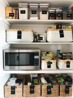 an organized pantry with lots of food and containers on the shelves, including a microwave