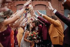 a group of people standing next to each other near a wall with confetti on it