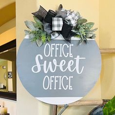 a sign that says office sweet office hanging on the wall next to a potted plant