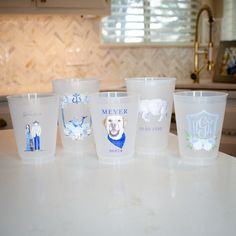 plastic cups with pictures of dogs on them sitting on a countertop in a kitchen