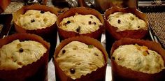 several muffins with chocolate chips in them sitting on a tray next to a tea pot