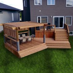 a wooden deck with chairs and table in the grass