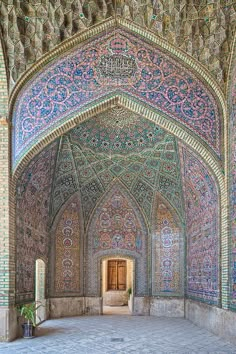 the inside of an ornate building with blue and green tiles on it's walls